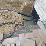 Provisorischer Anschluss der neuen Deckenstrahlheizung in der Kirche an die Heizungsanlage im Pfarrhaus nach einem Regenschauer